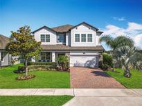 Charming two-story home with a brick driveway and well-manicured lawn at 2312 Panoramic Cir, Apopka, FL 32703