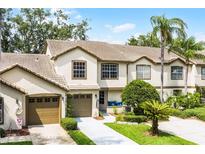 Inviting townhouse featuring a tile roof, two-car garage, and well-manicured landscaping at 2498 Saint Augustine Blvd, Haines City, FL 33844