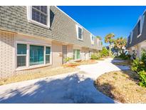 Charming townhome exterior featuring a well-maintained facade, gray roof, and inviting walkway surrounded by lush landscaping at 315 Glenview Blvd # 3, Daytona Beach, FL 32118