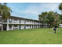 Multi-Gathering building featuring a green lawn, balconies, and mature trees, creating a serene and inviting atmosphere at 320 Lakeview St # 208, Orlando, FL 32804