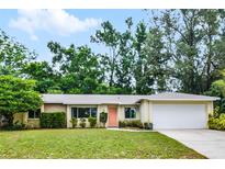 Charming single-story home featuring a well-maintained lawn, mature trees, and a welcoming front entrance at 327 Ketch Ct, Orlando, FL 32835