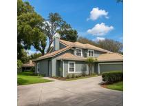 Charming two-story home features a lovely front yard, neutral color scheme, and a tile roof at 4652 Oak Arbor Cir, Orlando, FL 32808