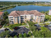Beautiful condo building with a tile roof overlooking a lake and scenic landscape at 4816 Cayview Ave # 20111, Orlando, FL 32819