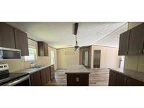 Features stainless steel appliances, a central island, and dark wood cabinets that offer plenty of storage at 56048 Blue Creek Rd, Astor, FL 32102