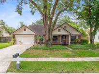 Charming single-story brick home featuring a well-manicured front yard and attached two car garage at 7249 Abbey Ln, Winter Park, FL 32792