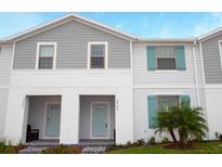 Charming townhome featuring light gray siding, a light-blue front door and matching shutters at 8944 Sydney Ave, Kissimmee, FL 34747