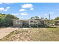 Charming single-story home featuring a cozy front porch and a well-maintained lawn with large driveway at 1508 Roger Babson Rd, Orlando, FL 32808