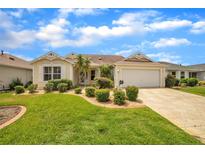 Charming single-story home with a well-manicured lawn and decorative landscaping at 17567 Se 81St Parnassus Ct, The Villages, FL 32162