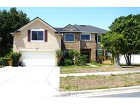 Charming two-story home with a brick facade, manicured lawn, attached garage, and inviting curb appeal at 211 Hunt St, Clermont, FL 34711