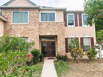 Charming home with brick facade, complemented by well-maintained landscaping and double-door entrance at 211 Hunt St, Clermont, FL 34711