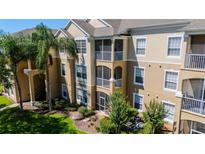 Elegant condominium building featuring balconies, lush landscaping, and a welcoming entrance at 2304 Silver Palm Dr # 304, Kissimmee, FL 34747