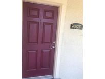 A classic burgundy-colored front door with an address plate on the side, creating an inviting entrance to the home at 2882 Club Cortile Cir # B, Kissimmee, FL 34746