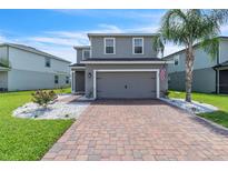 Charming two-story home featuring a brick driveway and a well-maintained front yard with meticulous landscaping at 3961 Crawley Down Loop, Sanford, FL 32773