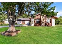 Charming single-Gathering home with wood and stone facade and lush green lawn and mature trees at 4265 Old Colony Rd, Mulberry, FL 33860