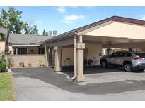 Beige home exterior showcasing a convenient carport and a neatly paved driveway with decorative potted plants along the walkway at 474 Windmeadows St # 0, Altamonte Springs, FL 32701