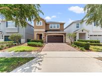 Charming two-story home featuring a brick-paved driveway, a two-car garage and beautiful landscaping at 480 Lasso Dr, Kissimmee, FL 34747