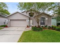 Charming single-Gathering home with a well-maintained lawn, flowering shrubs, and a two-car garage at 516 Brett Ct, Orlando, FL 32828