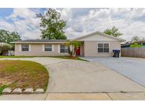 Charming single-story home with a wide driveway, red front door, and nicely landscaped front yard at 5822 Flori Ln, Orlando, FL 32808