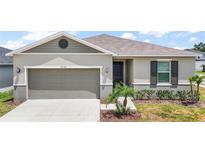 Charming single-story home with a neutral color palette, a well-manicured lawn, and attached garage at 7054 Cruz Ct, Lakeland, FL 33813