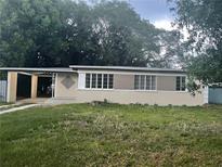 Cozy single-story home featuring a carport and a well-lit facade with many windows at 715 Mercado Ct, Orlando, FL 32807
