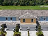 Charming townhomes feature colorful exteriors and individual garages with lovely landscaping at 812 Driving Range Ct, Reunion, FL 34747
