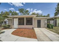 Charming single-story home featuring a screened porch and a tidy front yard with mulch at 108 N Truett St, Leesburg, FL 34748