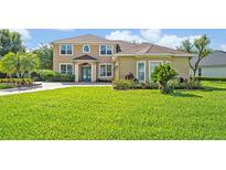 Charming two-story home with a well-manicured lawn, lush landscaping, and a beautiful paver driveway at 14545 Braddock Oak Dr, Orlando, FL 32837
