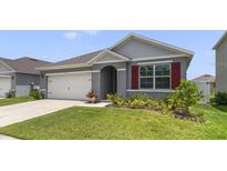Charming one-story home featuring a well-manicured lawn and a two-car garage at 1511 Barberry Dr, Kissimmee, FL 34744