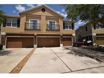 Townhouse exterior features a multi-car driveway, attached garages, and small balconies, with neutral color scheme at 15349 Oak Apple Ct # B, Winter Garden, FL 34787