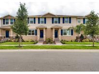 Charming townhomes with blue shutters and landscaping, offering a welcoming curb appeal at 1566 Dalehurst Ln, Kissimmee, FL 34744