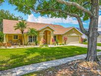 Inviting single-story home featuring a manicured lawn, well-kept landscaping, and a two-car garage at 1846 Branchwater Trl, Orlando, FL 32825