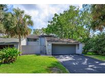 Charming home featuring a two-car garage, well-maintained lawn, and mature trees providing ample shade at 209 Sweet Gum Way, Longwood, FL 32779