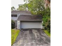Charming home featuring an attached two-car garage and a well-maintained driveway and mature trees at 209 Sweet Gum Way, Longwood, FL 32779