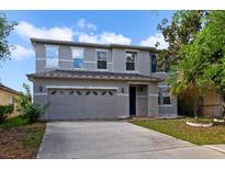 Two-story home featuring a neutral paint scheme, a two car garage, and simple landscaping at 2724 Amanda Kay Way, Kissimmee, FL 34744