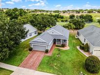 Charming home featuring a brick driveway, manicured lawn, and a golf course view, perfect for relaxed living at 3008 Pinnacle Ct, Clermont, FL 34711