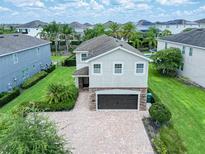 Beautiful two-story home with a brick driveway and a well-maintained landscaped front yard at 311 W Falls Dr, Kissimmee, FL 34747