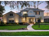 Charming two-story home with a landscaped front yard, illuminated walkway and welcoming double-door entrance at 3352 Park Grove Ct, Longwood, FL 32779