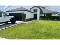 Charming single-story home with a well-manicured lawn and an attached two-car garage at 4297 Abaco Dr, Tavares, FL 32778
