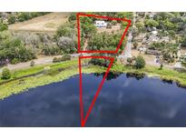 Stunning aerial view showcasing the property, serene lake, and verdant surroundings at 511 E Mirror Lake Dr, Fruitland Park, FL 34731