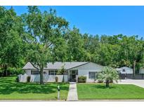 Charming single-story home featuring a well-manicured lawn, mature trees, and a welcoming front entrance at 711 Valencia Ct, Winter Garden, FL 34787