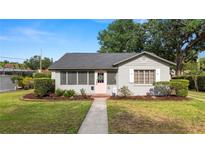 Charming single story home with gray paint, a pink front door and lush landscaping in the front yard at 814 Jefferson Ave, Lakeland, FL 33801