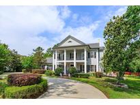 Elegant home featuring a grand two-story entrance with white columns and meticulously landscaped front yard at 830 Miami Springs Dr, Longwood, FL 32779