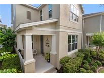 Charming front porch with white columns and space for seating, complemented by lush landscaping at 976 Eagle Bay St, Winter Springs, FL 32708