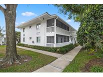 Inviting two-story condo featuring a screened-in porch and lush landscaping at 1140 S Orlando Ave # E11, Maitland, FL 32751