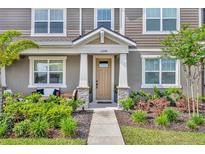 Inviting front entrance with stone accents, beige door, and lush landscaping that creates a warm and welcoming curb appeal at 11574 Buoy Point Pl, Orlando, FL 32832