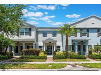 Charming townhouse with a well-manicured lawn, walkway, and attractive landscaping on a sunny day at 11631 Mystery Ln, Orlando, FL 32832