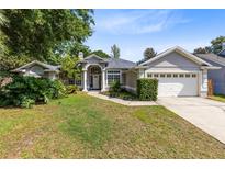Charming home featuring a well-manicured lawn, mature landscaping, and a welcoming front entrance at 1324 Saddleridge Dr, Orlando, FL 32835