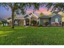 Charming home featuring stone accents, arched windows and lush green lawn at 1333 Killbricken Cir, Ormond Beach, FL 32174