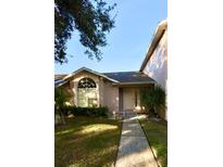 Charming single-story home featuring a well-manicured lawn and a walkway leading to the front door at 1603 Emily Ct, Kissimmee, FL 34744