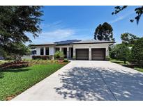 Charming home featuring a two-car garage, solar panels, and well-manicured landscaping with a spacious driveway at 1821 Windsor Dr, Winter Park, FL 32789